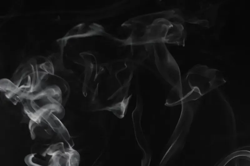 Wisps of smoke drifting in a dark room